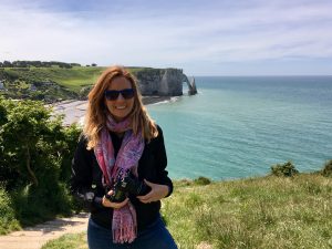 woman, Julia Willard, with the cliffs of Etretat behind her 