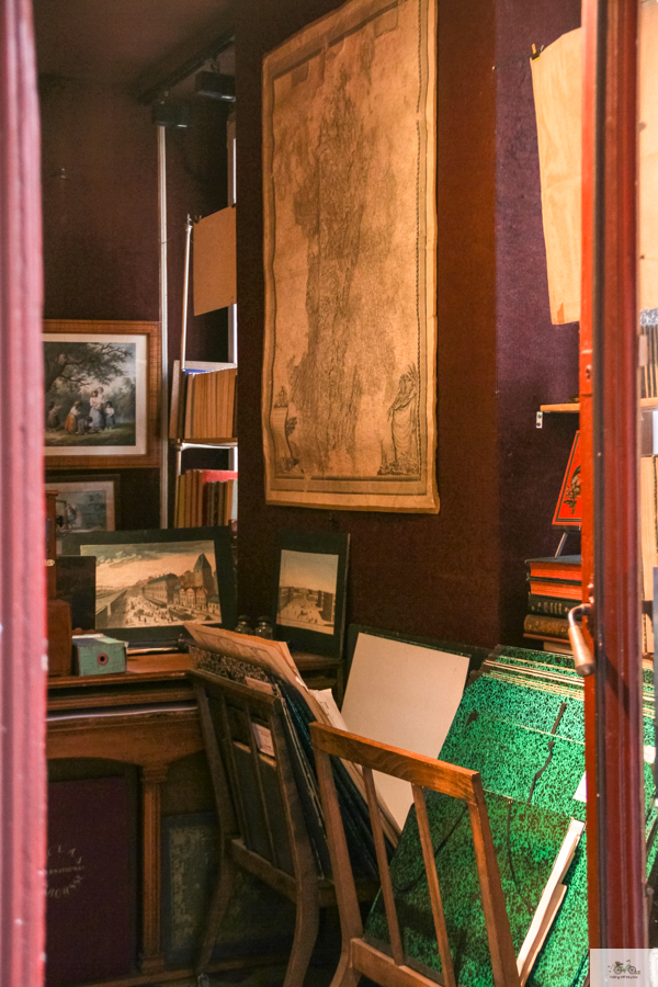 Maps and books hanging in shop in Beaune