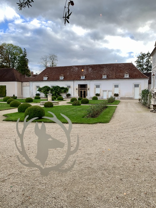 Front facing view or the 3 story white building in vineyards of the Cistercian Abbey of Pontigny